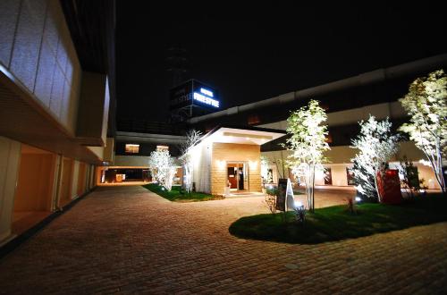 a building at night with trees in front of it at Hotel Free Style Okayama in Okayama