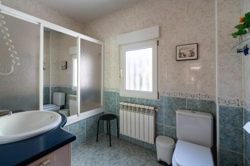 bagno con lavandino, servizi igienici e specchio di Casa Rural Las Melias a Ciudad Real