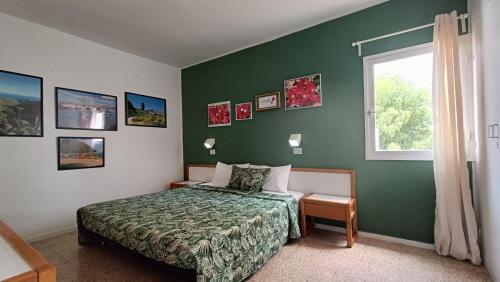 - une chambre avec un mur vert, un lit et une fenêtre dans l'établissement Bouganville en Eureka, à Costa del Silencio