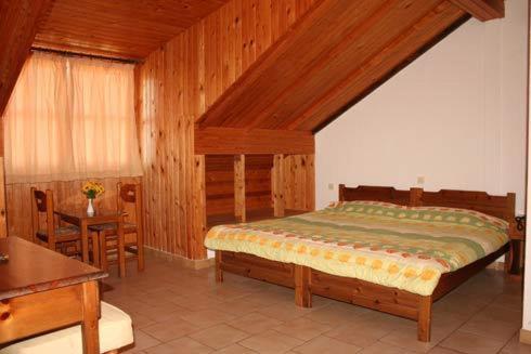 a bedroom with a large bed and a table at Vicky Rooms & Apartments in Limenas