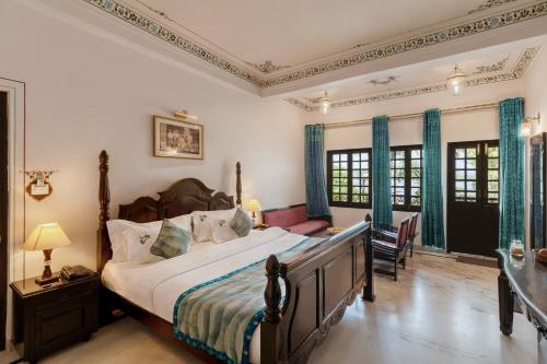 a bedroom with a bed and a table and chairs at Panna Vilas - A Lake Facing Boutique Hotel in Udaipur