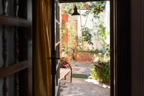 Une porte ouverte s'ouvre sur une terrasse dotée d'un banc. dans l'établissement La Asomada del Gato, à La Laguna