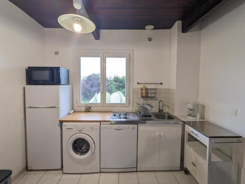 une cuisine avec une machine à laver et une fenêtre dans l'établissement T2 APPIETTO, à Appietto