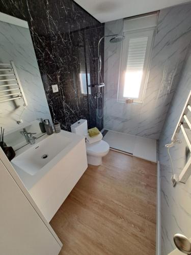 a bathroom with a white sink and a toilet at Casa dos Paralelos in Moledo
