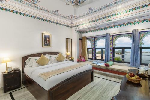 a bedroom with a large bed and windows at Panna Vilas - A Lake Facing Boutique Hotel in Udaipur