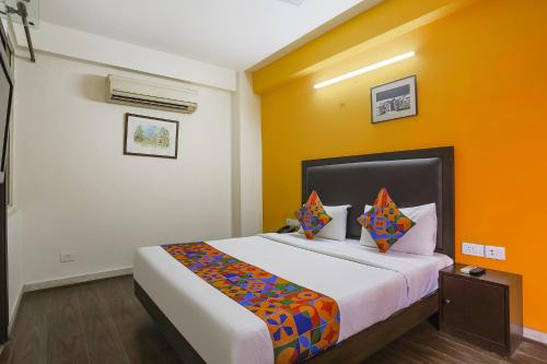a bedroom with a large bed with yellow walls at FabHotel All In One in New Delhi