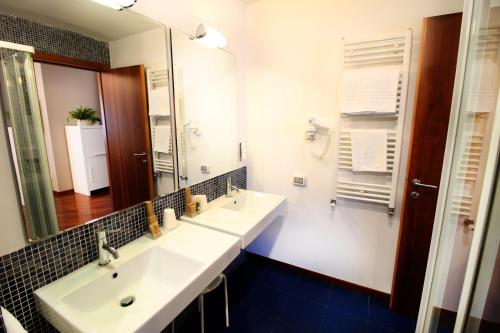 a bathroom with two sinks and a large mirror at Regiohotel Manfredi in Manfredonia