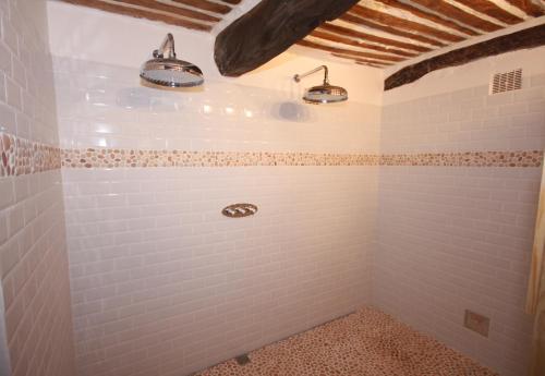 a bathroom with white tiles and two lights at Hameau des Oraisonis in Bras-dʼAsse