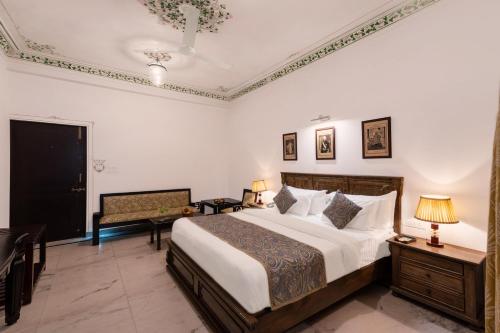 a bedroom with a large bed and a chair at Panna Vilas - A Lake Facing Boutique Hotel in Udaipur