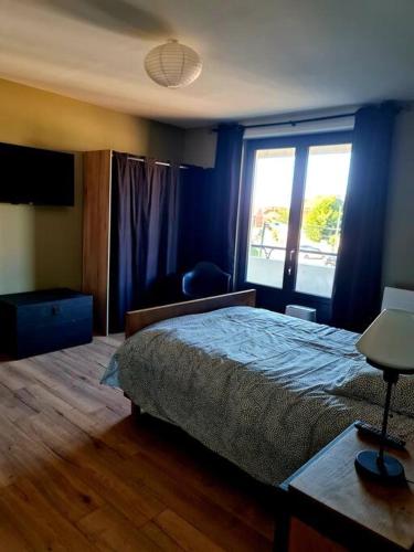 a bedroom with a bed and a large window at Appartement 2 chambres in Aire-sur-la-Lys
