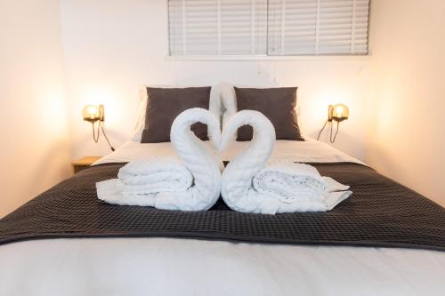 two swans towels sitting on top of a bed at Golden Rays Beach Scheveningen The Hague Appartment 180B in Scheveningen