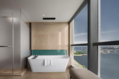 ein Badezimmer mit einer weißen Badewanne und einem großen Fenster in der Unterkunft Shantou Marriott Hotel in Shantou
