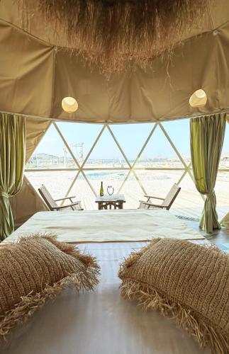 a bedroom with a bed in a tent with windows at Boutique Citadel in Eforie Nord