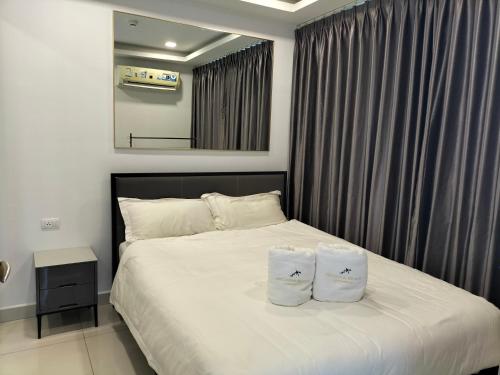 a bedroom with a bed with two pillows on it at Arcadia beach continental in Pattaya South