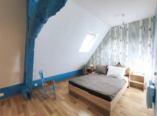 ein Schlafzimmer mit einem Bett und einer blauen Wand in der Unterkunft Maison Normande proche mer in Blosseville
