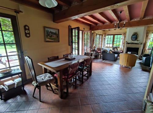 un salon avec une table et des chaises en bois dans l'établissement Maison campagne proche mer, golf, à Pleine-sève