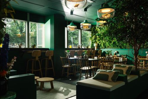 ein Restaurant mit Tischen und Stühlen und eine Bar in der Unterkunft Qbic Amsterdam WTC in Amsterdam