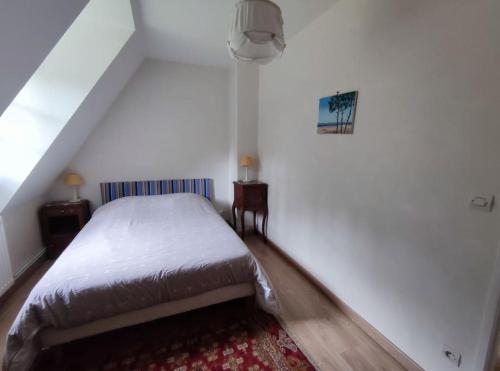 - une chambre blanche avec un lit et un tapis dans l'établissement Maison campagne proche mer, golf, à Pleine-sève