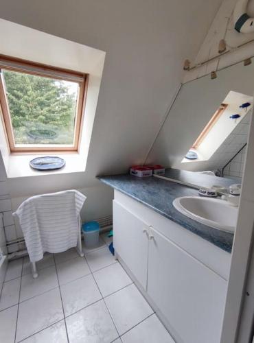 une salle de bain avec un lavabo et une fenêtre dans l'établissement Maison campagne proche mer, golf, à Pleine-sève
