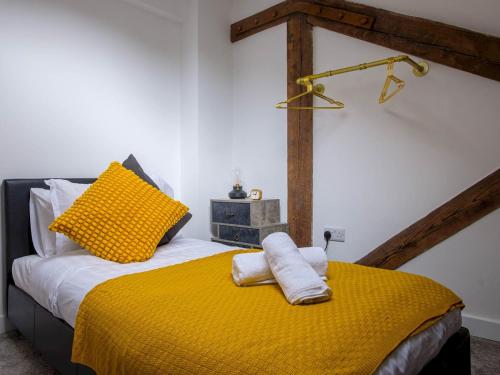 um quarto com uma cama com um cobertor amarelo em Pass the Keys Wonderful historic conversion em Doncaster