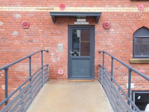 a black door on a brick building with a ramp at Pass the Keys Wonderful historic conversion in Doncaster