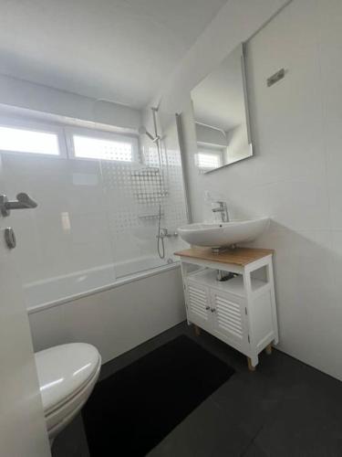biała łazienka z umywalką i toaletą w obiekcie OF01 71m² große Unterkunft für bis zu 5 Personen w mieście Heusenstamm