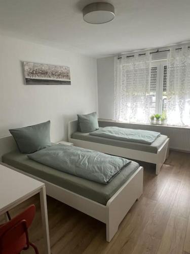 1 dormitorio con 2 camas y ventana en OF01 71m² große Unterkunft für bis zu 5 Personen, en Heusenstamm