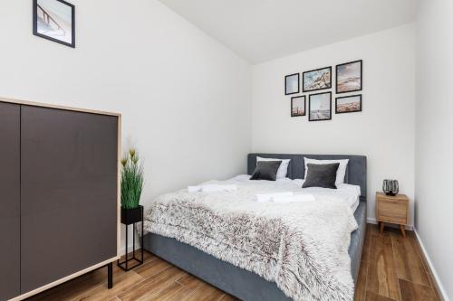 sypialnia z łóżkiem i białą ścianą w obiekcie Apartament Słoneczne Pilice w Jastrzębiej Górze