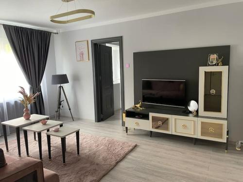 a living room with a flat screen tv and a couch at Britannia ShortStay Apartment Caransebes in Caransebeş