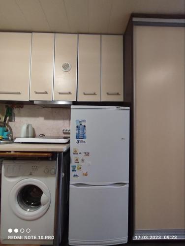 a kitchen with a refrigerator and a washing machine at Уютная 1я смарт-квартира ,м.Дворец спорта. in Kharkiv