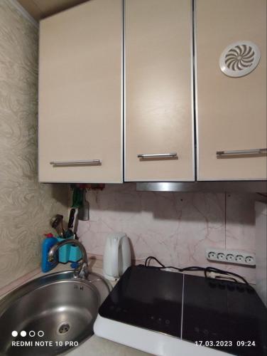a kitchen counter with a sink and a stove at Уютная 1я смарт-квартира ,м.Дворец спорта. in Kharkiv