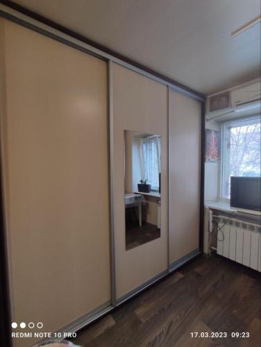 a room with a sliding glass door with a mirror at Уютная 1я смарт-квартира ,м.Дворец спорта. in Kharkiv