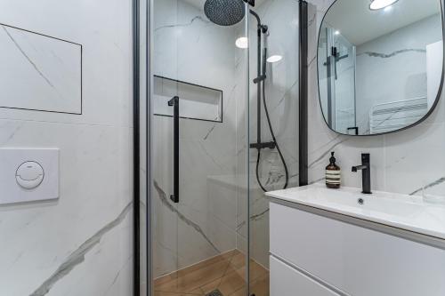 a bathroom with a shower and a sink and a mirror at L'Embarcadère - Petit paradis 1ère ligne vue mer in Arcachon