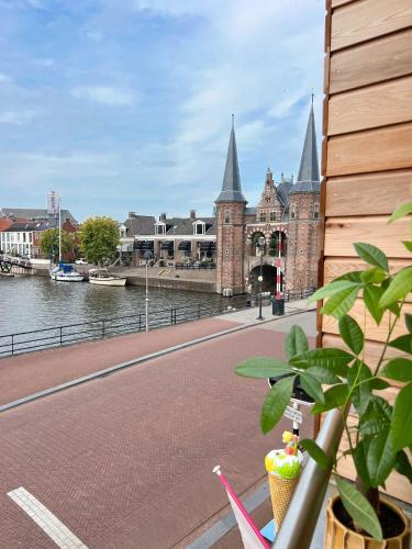 a building with towers on the side of a river at Short Stay Waterpoort in Sneek