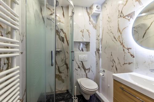 a bathroom with a shower and a toilet and a sink at Azul - Maison avec jardin à 200m de la plage in Courseulles-sur-Mer