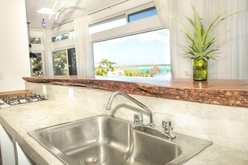 a kitchen with a sink and a large window at Camino del Alma Apartments in Bacalar