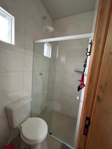 uma casa de banho com um WC e uma cabina de duche em vidro. em Casa Copacabana 2 em Urubici