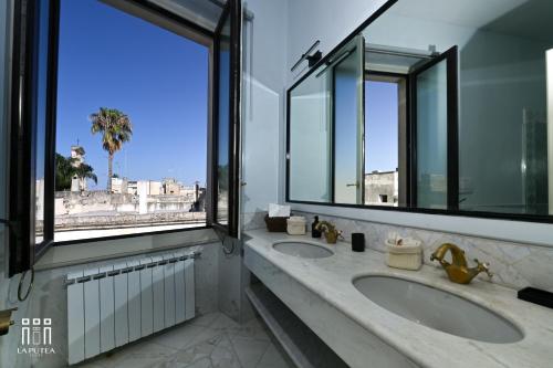 a bathroom with two sinks and two windows at LA PUTEA SUITE in Lecce