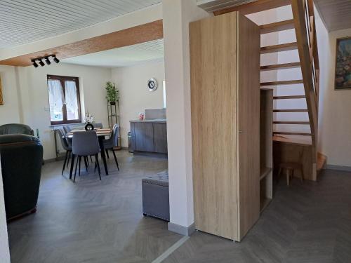 Una sala de estar con escalera y un comedor. en Maison Maurer, en Aschbach