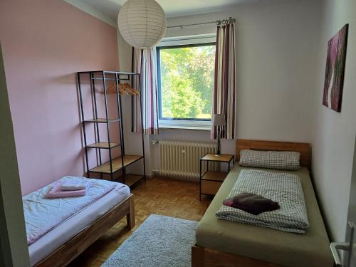 a small room with two beds and a window at Ferienhaus Brenzblick in Gundelfingen