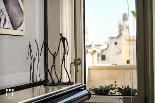 a window with a plant on a window sill at LA PUTEA SUITE in Lecce