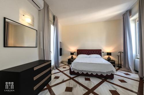 a bedroom with a bed and two windows at LA PUTEA SUITE in Lecce
