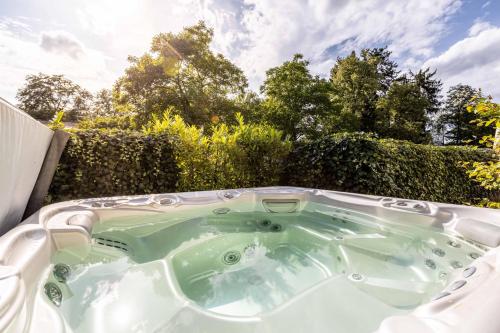 a jacuzzi tub in a backyard with trees at Bauhausvilla am Ammersee in Herrsching am Ammersee