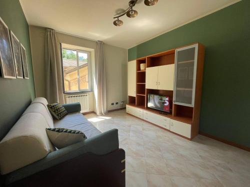 a living room with a couch and a tv at Il Rifugio by Holiday World in Castagnelo
