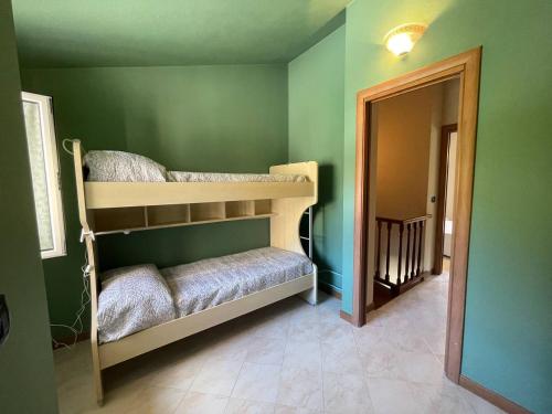 a room with two bunk beds in a green wall at Il Rifugio by Holiday World in Castagnelo
