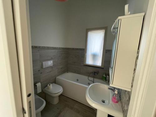 a bathroom with a tub and a toilet and a sink at Casa in affitto in Ragalna