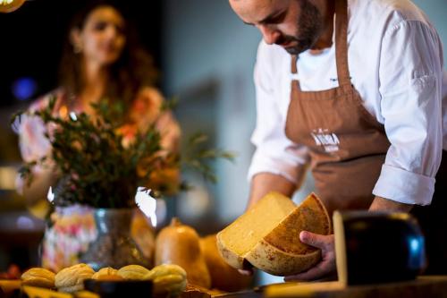 a man holding a slice of bread in front of a table at Octant Ponta Delgada in Ponta Delgada