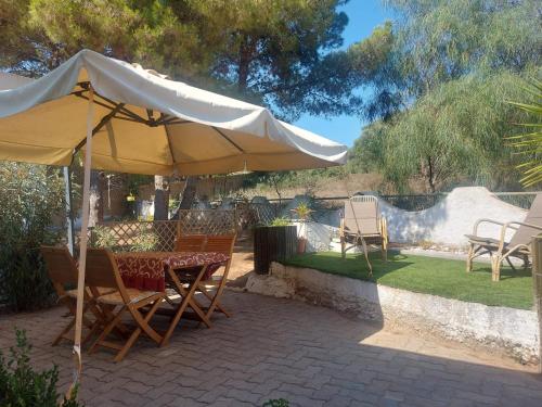 a table and chairs under an umbrella on a patio at Georgia in Porto Pino