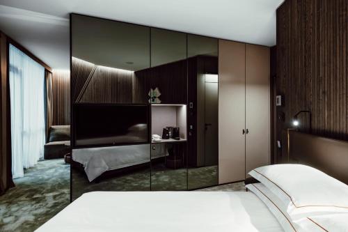 um quarto com uma cama e uma grande parede de vidro em Amberton Green SPA Druskininkai em Druskininkai