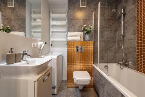 a bathroom with a sink and a toilet and a shower at Apartament 24 AbsyntApart Rynek Wrocław in Wrocław